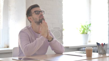 Photo for Young Adult Man Feeling Worried While Sitting in Office - Royalty Free Image