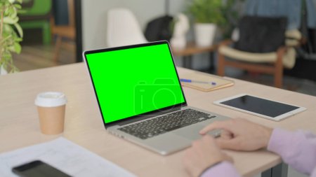 Téléchargez les photos : Homme utilisant un ordinateur portable avec écran Chroma vert - en image libre de droit