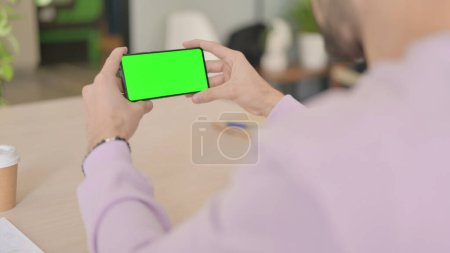 Téléchargez les photos : Homme tenant Smartphone avec écran vert - en image libre de droit