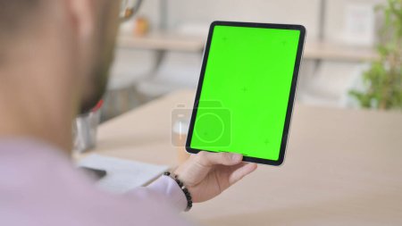 Téléchargez les photos : Homme utilisant la tablette avec écran Chroma vert - en image libre de droit
