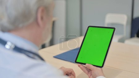 Téléchargez les photos : The Close Up of Old Doctor Using Digital Tablet with Green Screen - en image libre de droit
