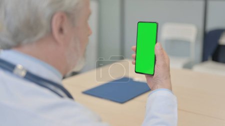 Photo for The Close Up of Old Doctor Using Smartphone with Green Screen - Royalty Free Image