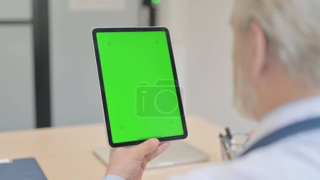 Téléchargez les photos : The Old Doctor Using Digital Tablet with Green Screen - en image libre de droit