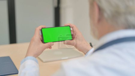 Photo for The Old Doctor Watching Smartphone with Chroma Key - Royalty Free Image