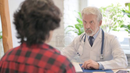 Photo for The Old Doctor Talking with Patient in Clinic - Royalty Free Image