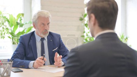 Téléchargez les photos : The Old Businessman Discussing Work with Businessman in Office - en image libre de droit
