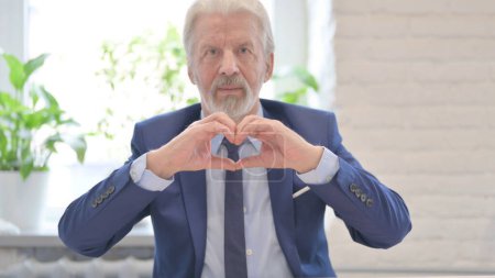 Téléchargez les photos : The Loving Old Businessman showing Heart Shape by Hands - en image libre de droit