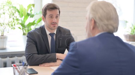 Téléchargez les photos : The Businessman Discussing Work with Senior Old Businessman in Office - en image libre de droit