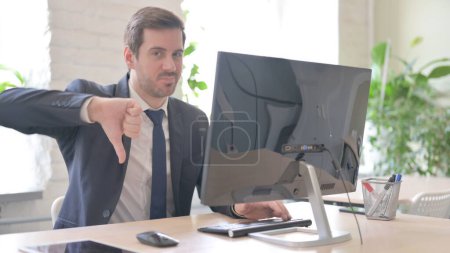 Téléchargez les photos : The Thumbs Down by Young Adult Businessman while Using Desktop Computer - en image libre de droit