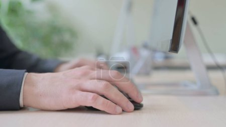 Téléchargez les photos : The Side View of Young Businessman Using Mouse and Typing on Desktop Keyboard - en image libre de droit