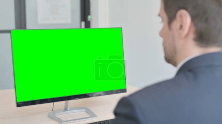 Téléchargez les photos : The Young Businessman Working on Computer with Green Screen - en image libre de droit