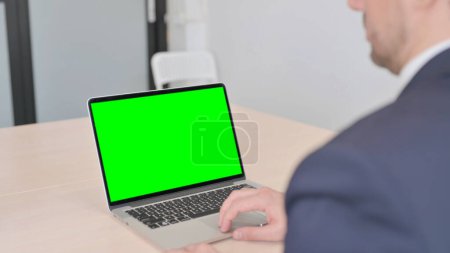 Téléchargez les photos : The Young Businessman Working on Laptop with Green Screen - en image libre de droit