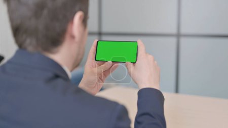 Téléchargez les photos : The Close Up of Young Businessman Watching Smartphone with Green Screen - en image libre de droit