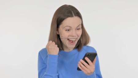 Téléchargez les photos : Femme occasionnelle Célébrant le succès sur Smartphone sur fond blanc - en image libre de droit