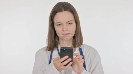 Téléchargez les photos : Jeune médecin naviguant sur Smartphone sur fond blanc - en image libre de droit