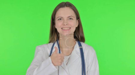Téléchargez les photos : Pouces levées par un jeune médecin sur fond vert - en image libre de droit