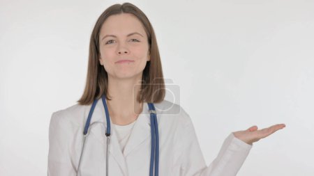 Photo for Young Doctor Showing on Side on White Background - Royalty Free Image