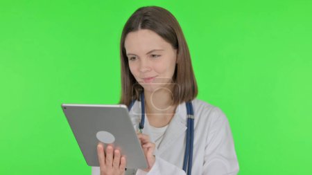 Téléchargez les photos : Jeune médecin utilisant la tablette numérique sur fond vert - en image libre de droit
