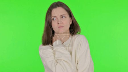 Téléchargez les photos : Femme occasionnelle ayant la douleur au cou sur fond vert - en image libre de droit