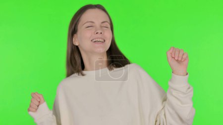 Téléchargez les photos : Femme décontractée dansant dans la joie sur fond vert - en image libre de droit
