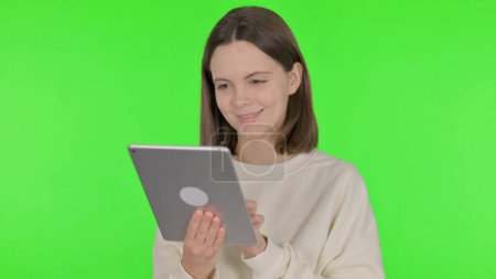 Téléchargez les photos : Femme occasionnelle en utilisant la tablette numérique sur fond vert - en image libre de droit