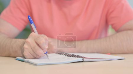 Foto de Close up of Young Man Writing in Office - Imagen libre de derechos