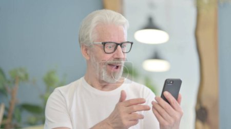 Téléchargez les photos : Portrait of Senior Old Man Celebrating Success on Smartphone - en image libre de droit