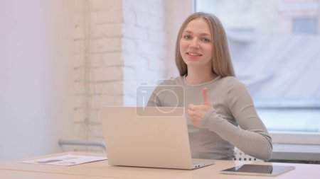 Téléchargez les photos : Thumbs Up by Creative Young Woman Working on Laptop - en image libre de droit