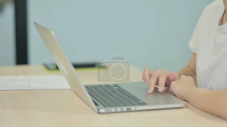 Téléchargez les photos : Vue latérale de la dactylographie des mains féminines sur ordinateur portable - en image libre de droit