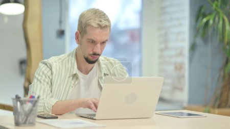 Photo for Casual Young Man Typing on Laptop - Royalty Free Image