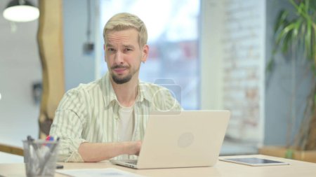 Photo for Young Man Shaking Head in Rejection while Working on Laptop - Royalty Free Image