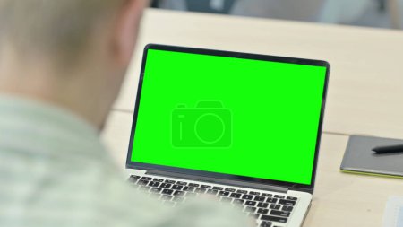 Foto de Hombre que trabaja en el ordenador portátil con la pantalla verde de la llave del croma - Imagen libre de derechos