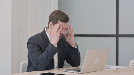 Photo for Businessman having Headache while Working on Laptop - Royalty Free Image