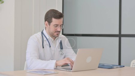 Téléchargez les photos : Docteur tapant sur ordinateur portable dans la clinique - en image libre de droit