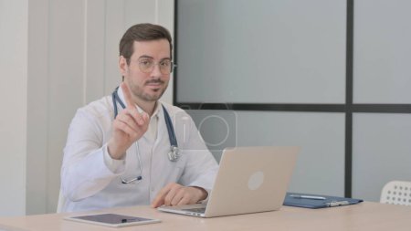 Photo for Doctor Shaking Head and Finger in Rejection while Working on Laptop - Royalty Free Image