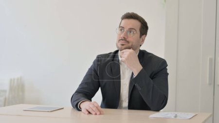 Photo for Pensive Businessman Thinking while Sitting at Work - Royalty Free Image