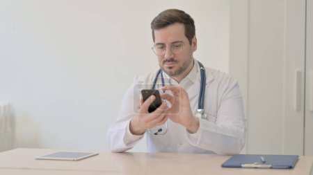 Téléchargez les photos : Médecin Naviguer sur Smartphone dans Clinique - en image libre de droit