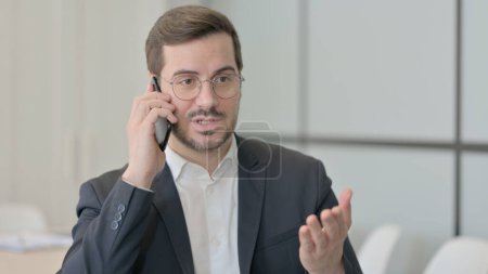 Téléchargez les photos : Jeune homme d'affaires parlant au téléphone - en image libre de droit