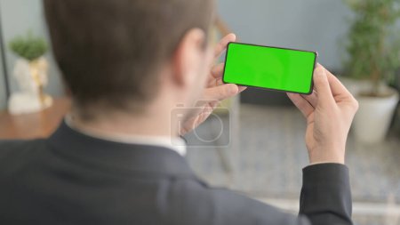 Foto de Empresario sosteniendo Smartphone con pantalla verde - Imagen libre de derechos