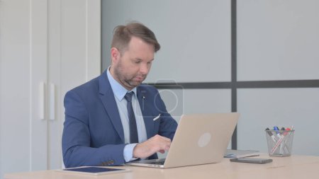 Téléchargez les photos : Homme d'affaires occupé travaillant sur ordinateur portable - en image libre de droit