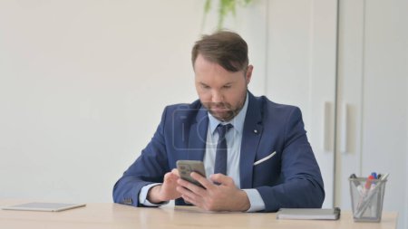 Photo for Businessman Using Smartphone at Work - Royalty Free Image