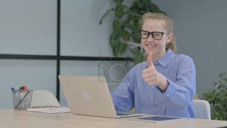 Photo for Thumbs Up by Young Woman on Laptop - Royalty Free Image