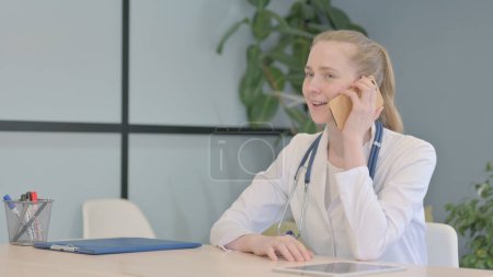 Téléchargez les photos : Médecin féminin parlant au téléphone à la clinique - en image libre de droit