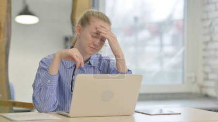 Téléchargez les photos : Jeune femme avec mal de tête Travailler sur ordinateur portable - en image libre de droit