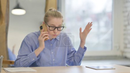 Foto de Mujer joven enojada hablando por teléfono - Imagen libre de derechos