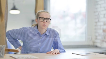 Photo for Young Woman with Back Pain Sitting at Work - Royalty Free Image