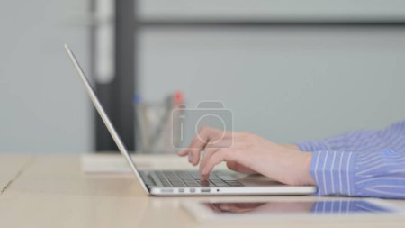 Téléchargez les photos : Vue latérale de Businesswoman travaillant sur ordinateur portable - en image libre de droit