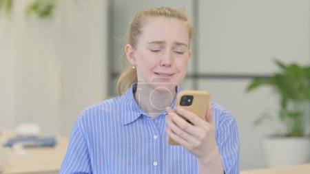 Photo for Portrait of Young Woman Shocked by Loss on Smartphone - Royalty Free Image