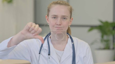 Téléchargez les photos : Thumbs Down by Female Doctor in Clinic - en image libre de droit