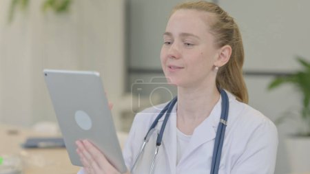 Téléchargez les photos : Portriat de femme médecin faire chat vidéo sur tablette - en image libre de droit